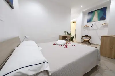 a bedroom with a white bed with roses on the floor at Phoenix Apartment in Terrasini