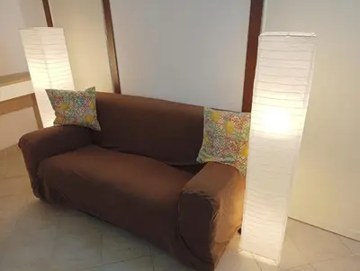 a brown couch and two lamps in a room at Phoenix Apartment in Terrasini