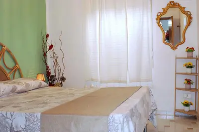 a bedroom with a large bed and a mirror at Villa Rosetta vacanze al mare in Carini