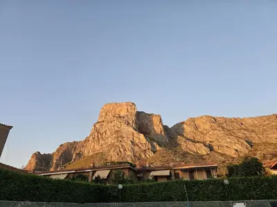 a building in front of a rocky mountain at Villa Eufrosine in Palermo
