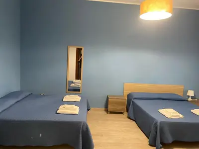 two beds in a blue room with towels on them at Villa Eufrosine in Palermo