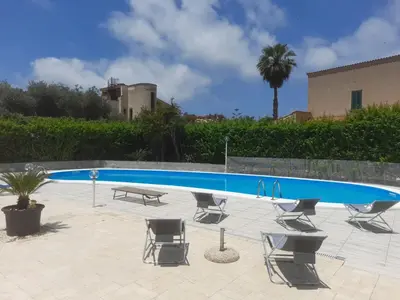 a swimming pool with chairs and a table and a bench at Villa Eufrosine in Palermo