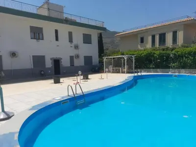 a large swimming pool in front of a house at Villa Eufrosine in Palermo