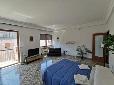 a large bedroom with a blue bed and a couch at La Casa del Capo in Palermo