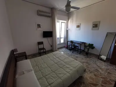 a bedroom with a large bed and a table at La Casa del Capo in Palermo