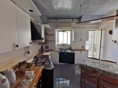 a kitchen with white cabinets and a stove top oven at La Casa del Capo in Palermo