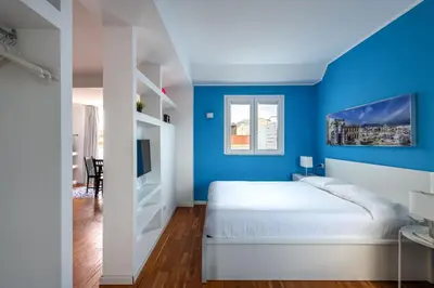 a bedroom with blue walls and a white bed at Vista sulle Cupole by Wonderful Italy in Palermo