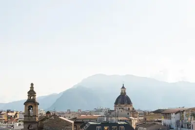a view of a city with a mountain in the background at Vista sulle Cupole by Wonderful Italy in Palermo