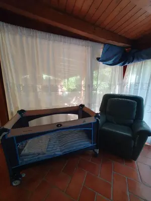 a couch and a chair in a room with a window at La Casetta del Melograno in Mondello
