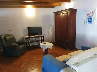 a living room with a couch and a tv at La Casetta del Melograno in Mondello