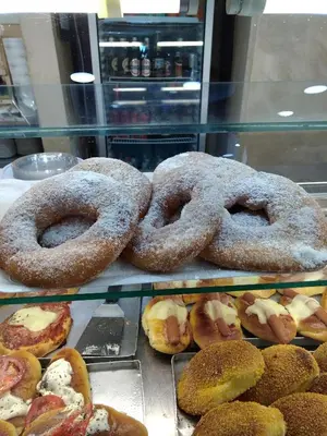 four donuts in a display case in a bakery at La Casetta del Melograno in Mondello
