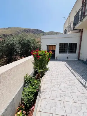 a walkway with flowers in front of a building at La Chiocciola 2 Bed&Breakfast in Castelluzzo