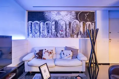 a living room with a couch and a painting on the wall at Luxury suite 2 min dal Politeama - Free Parking in Palermo