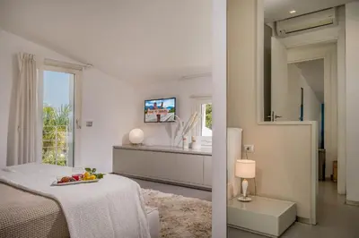 a white bedroom with a bed and a window at Villa Sikelia in Alcamo