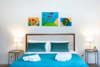 a bedroom with a blue bed with two lamps at Da Olga in Palermo