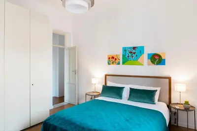 a bedroom with a bed with blue sheets and two tables at Da Olga in Palermo