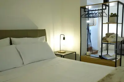 a bedroom with a large white bed and a shelf at Sea apartment 1 in Palermo