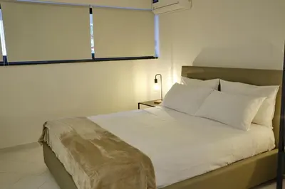 a bedroom with a bed with white sheets and a window at Sea apartment 1 in Palermo
