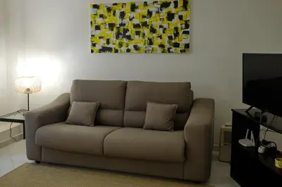 a living room with a couch and a painting on the wall at Sea apartment 1 in Palermo
