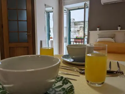 a table with a bowl and two glasses of orange juice at Iverlid Ballarò in Palermo