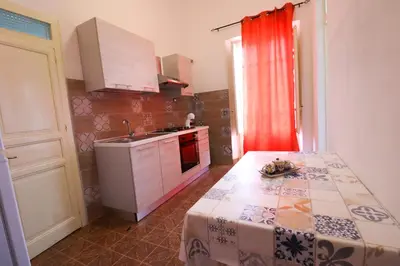 a small kitchen with a table and a sink at Holiday House Marconi in Castellammare del Golfo