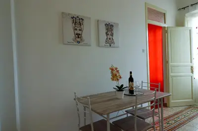 a dining room with a table and a bottle of wine at Holiday House Marconi in Castellammare del Golfo