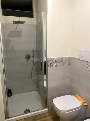 a bathroom with a shower with a toilet and a sink at Casa Woow in Carini