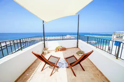 a balcony with two chairs and a view of the ocean at Casa del Pescatore Terrasini in Terrasini
