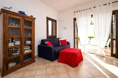 a living room with a blue couch and a red stool at Villa Scirocco Macari in Macari