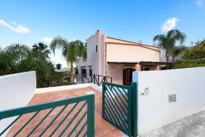 a house with a gate in front of a building at Villa Scirocco Macari in Macari
