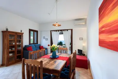 a dining room with a table and a couch at Villa Scirocco Macari in Macari