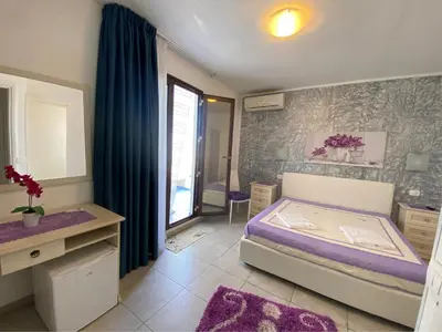 a bedroom with a bed and a bathroom with a window at B&B Le Onde Del Mare in San Vito lo Capo