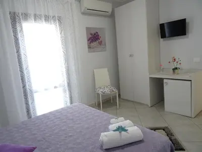 a bedroom with a bed and a window and a table at B&B Le Onde Del Mare in San Vito lo Capo