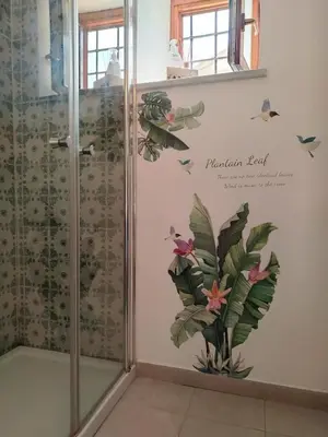 a bathroom with a shower with flowers on the wall at Peri Peri House - Palermo Centro in Palermo