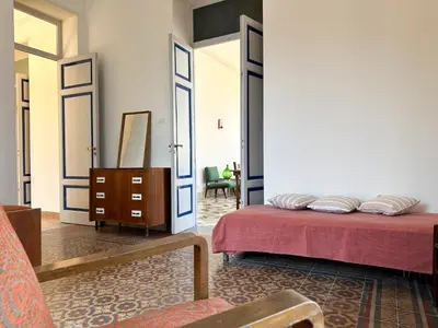a bedroom with two beds and a chair and a mirror at Casa Stella Splendida Villa sul Mare in Palermo