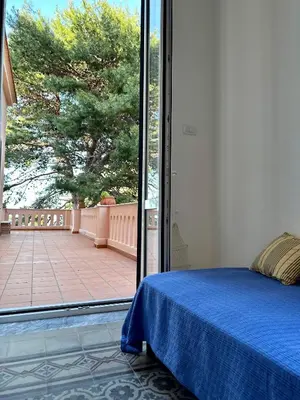 a bedroom with a bed and a large sliding glass door at Casa Stella Splendida Villa sul Mare in Palermo