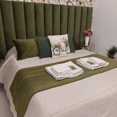 a green and white bed with towels on it at Borgo La Chiusa in Cinisi