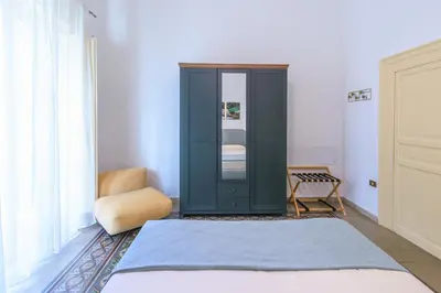 a bedroom with a green cabinet and a chair at Vintage Rooms in Palermo