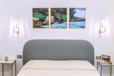 a bedroom with a bed with four pictures on the wall at Vintage Rooms in Palermo