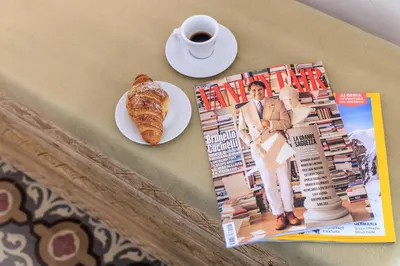 a table with a plate of pastry and a cup of coffee at Vintage Rooms in Palermo