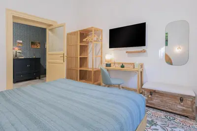 a bedroom with a bed and a desk and a tv at Vintage Rooms in Palermo