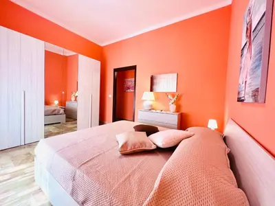 a bedroom with orange walls and a bed with two pillows at Domus Aurea in Isola delle Femmine