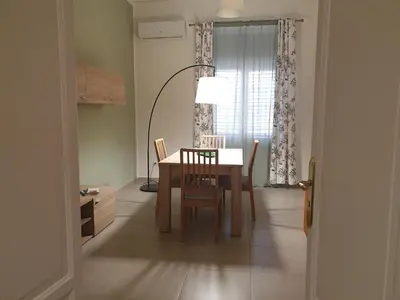 a dining room with a table and chairs and a window at CasALE Sampó in Palermo