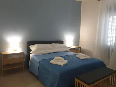 a bedroom with a blue bed with two towels on it at CasALE Sampó in Palermo