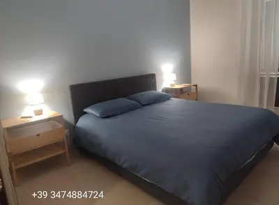 a bedroom with a blue bed with two night stands at CasALE Sampó in Palermo