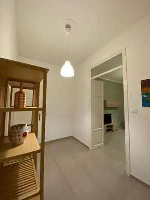 a living room with a table and a hallway at CasALE Sampó in Palermo