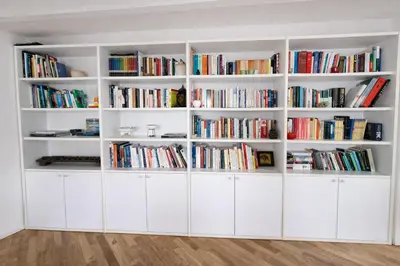 a large white book shelf filled with books at Palazzo Moncada appartamento 2 in Palermo