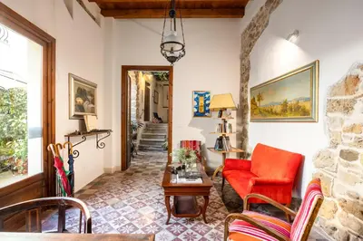 a living room with a red chair and a table at Sette Fate Suites & Spa in Palermo