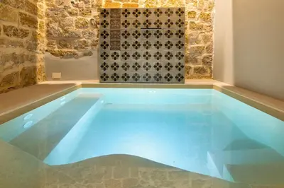 a swimming pool in a room with a tile wall at Sette Fate Suites & Spa in Palermo