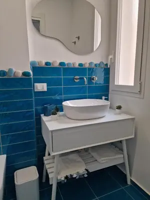 a bathroom with a sink and a mirror and blue tiles at The waves in Terrasini